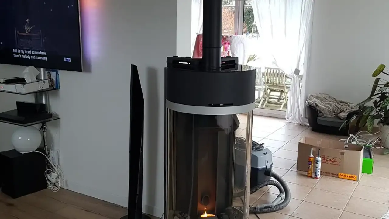 Poêle à granulés gris anthracite en fonctionnement dans un salon meublé